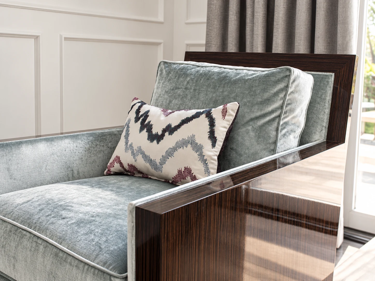 Upholstered accent chair with a patterned cushion and polished wood arms